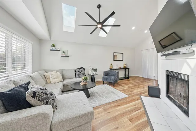 a living room with furniture a fireplace and a large window