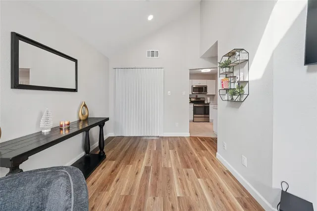 a view of a bedroom with a bed and wooden floor