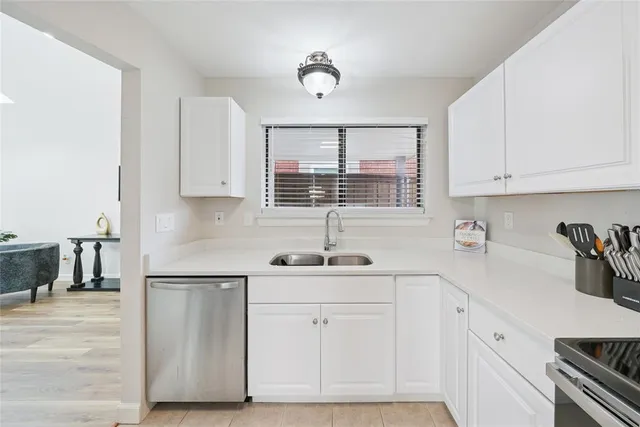 a kitchen with white cabinets and sink