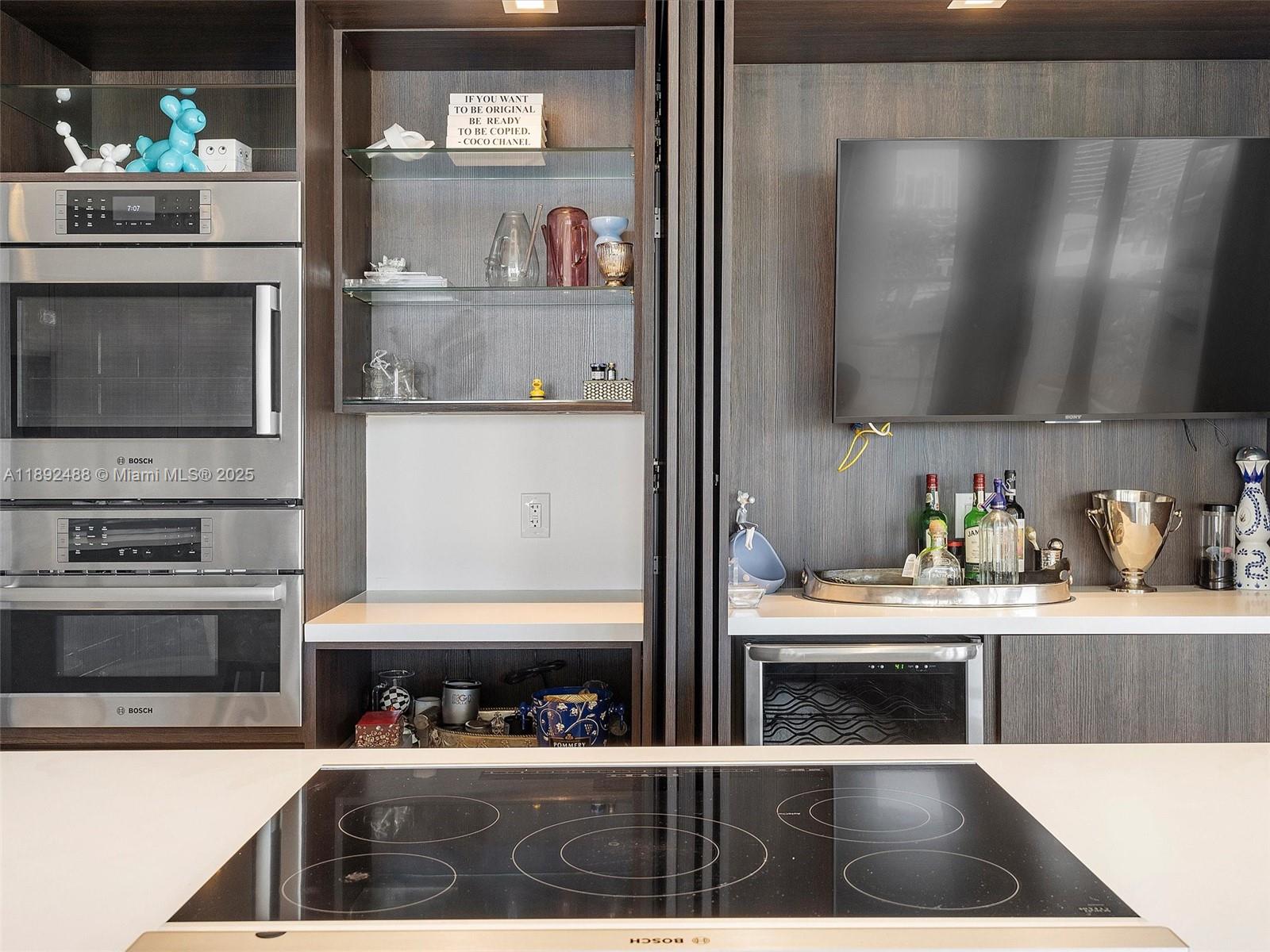 4000 Island Boulevard, Unit 606 Aventura, FL 33160 - Photo 18 of 36 a kitchen with stainless steel appliances kitchen island granite countertop a refrigerator and a stove top oven
