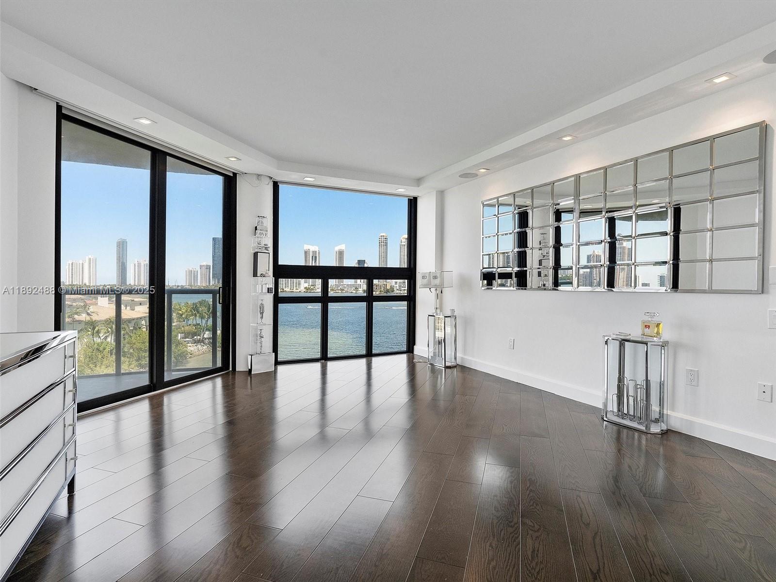 4000 Island Boulevard, Unit 606 Aventura, FL 33160 - Photo 23 of 36 an empty room with wooden floor and windows