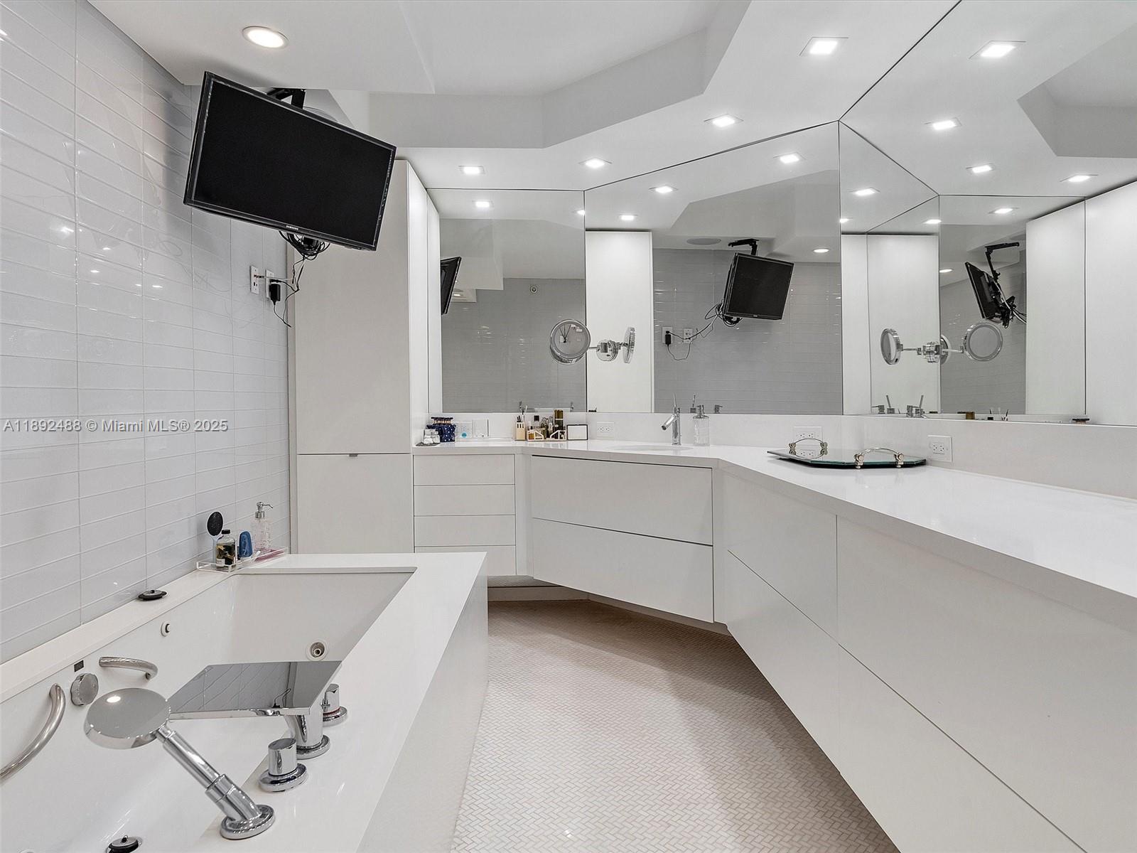 4000 Island Boulevard, Unit 606 Aventura, FL 33160 - Photo 27 of 36 a bathroom with a double vanity sink a mirror and a bathtub