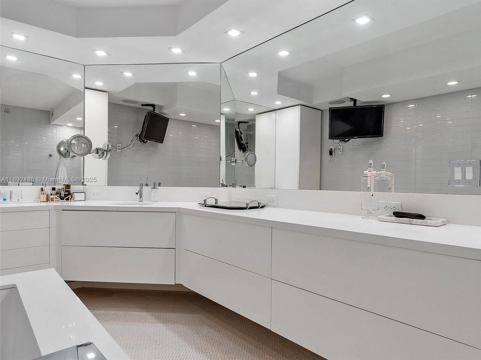 4000 Island Boulevard, Unit 606 Aventura, FL 33160 - Photo 28 of 36 a bathroom with a sink a large mirror and a toilet