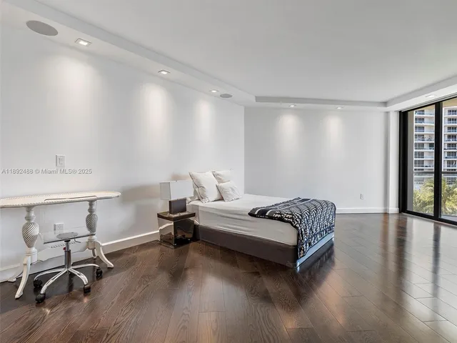 a spacious bedroom with a bed and a chair