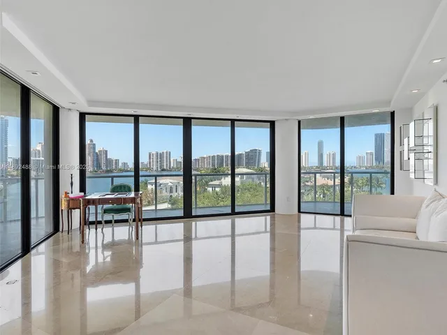 a living room with furniture and floor to ceiling windows