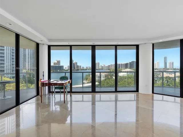 a living room with furniture and floor to ceiling windows