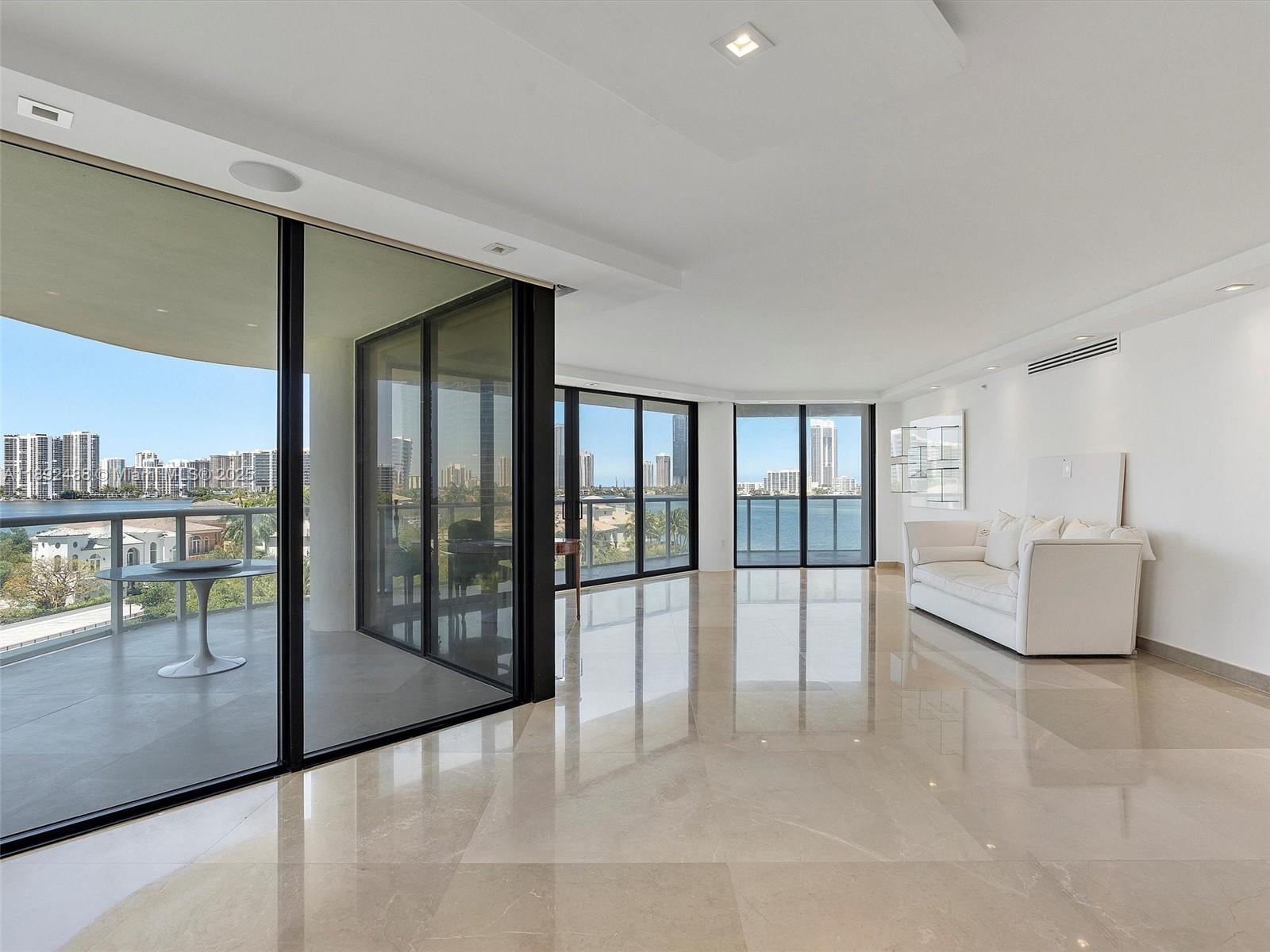 4000 Island Boulevard, Unit 606 Aventura, FL 33160 - Photo 10 of 36 a living room with furniture and large windows
