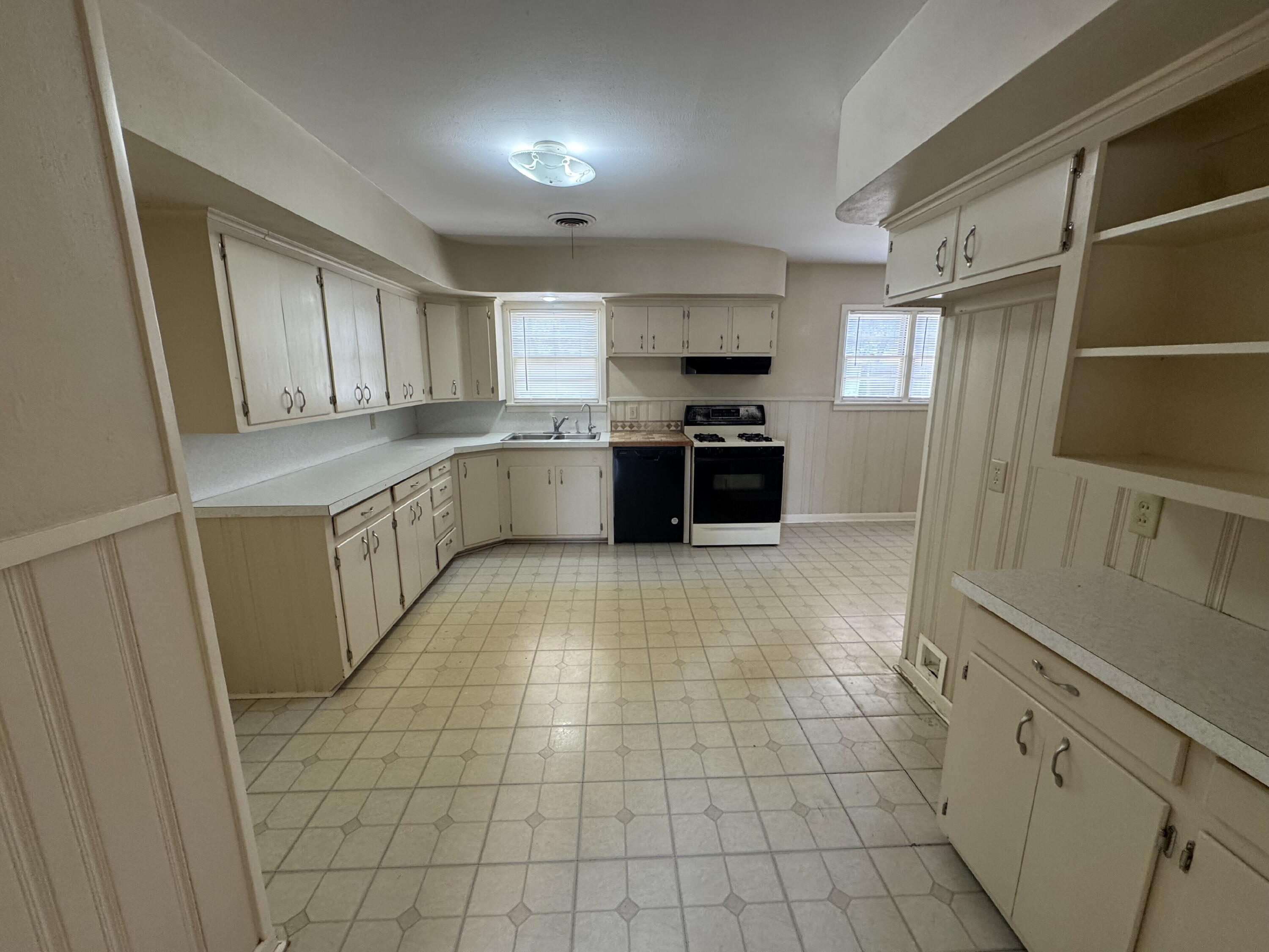 3605 40th Street Lubbock, TX 79413 - Photo 3 of 11 a kitchen with stainless steel appliances a sink a stove a refrigerator and cabinets