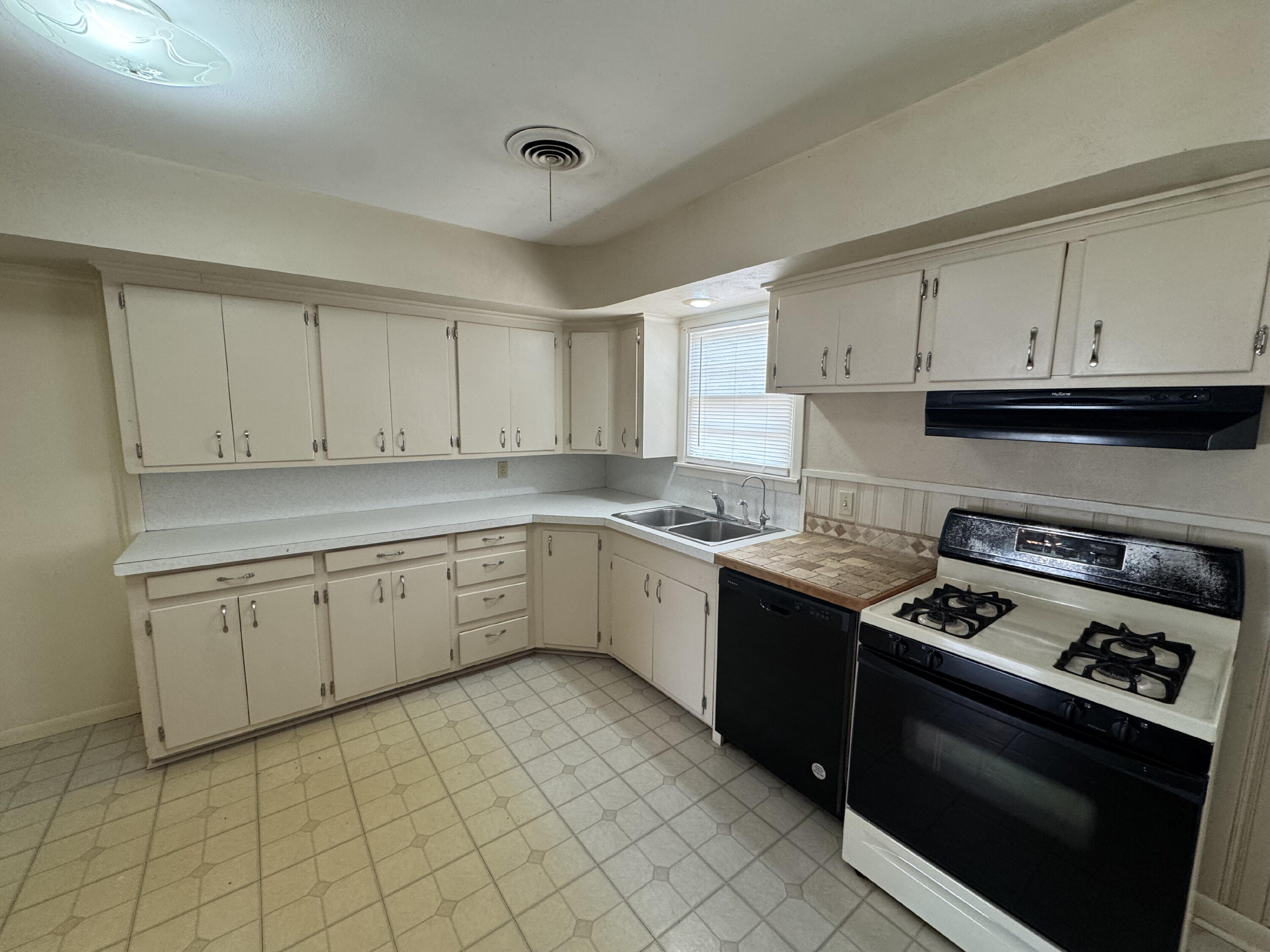 3605 40th Street Lubbock, TX 79413 - Photo 4 of 11 a kitchen with cabinets appliances and a window