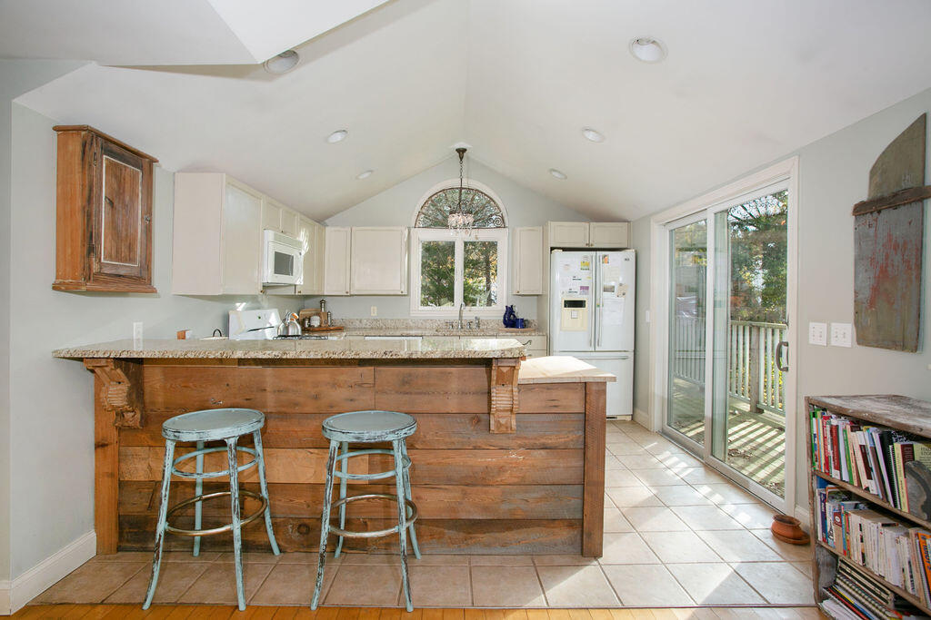 5 Scraggy Neck Rd Extension Bourne, MA 02534 - Photo 8 of 37 a dining hall with stainless steel appliances granite countertop a stove a sink a dining table and chairs