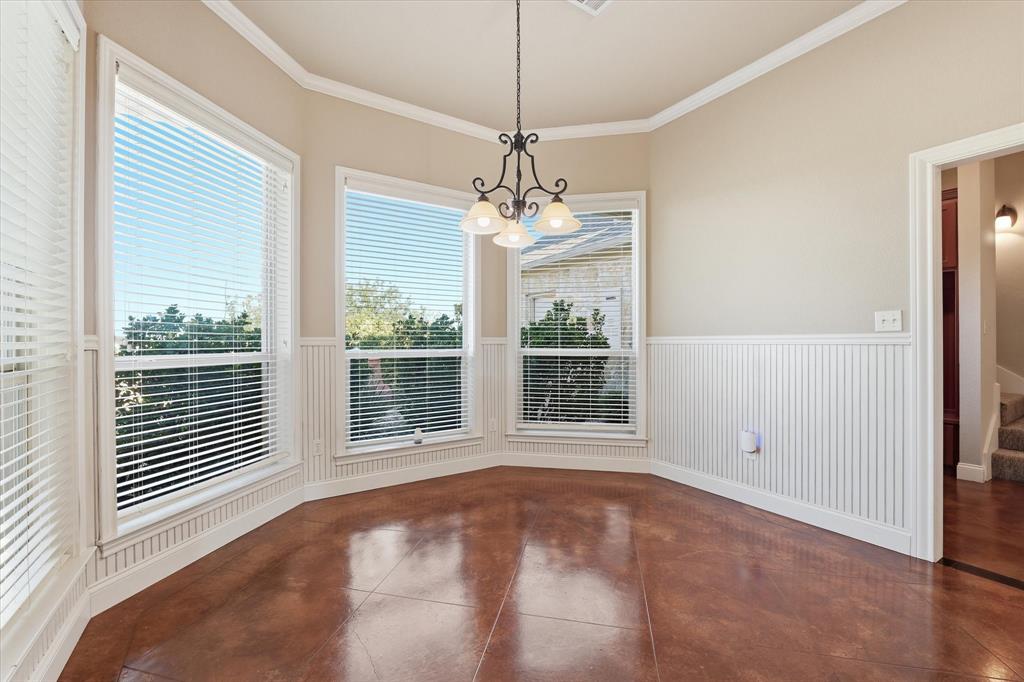 504 Casa Del Rancho Road Lorena, TX 76655 - Photo 13 of 40 Bay window alcove featuring three large windows, beadboard wainscoting, crown molding, a decorative chandelier, and polished concrete flooring