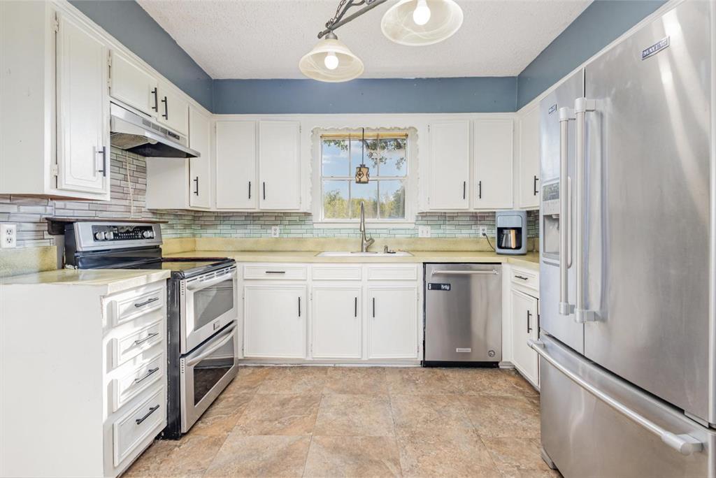 18888 Highway 274 Kemp, TX 75143 - Photo 10 of 30 a kitchen with white cabinets and white appliances