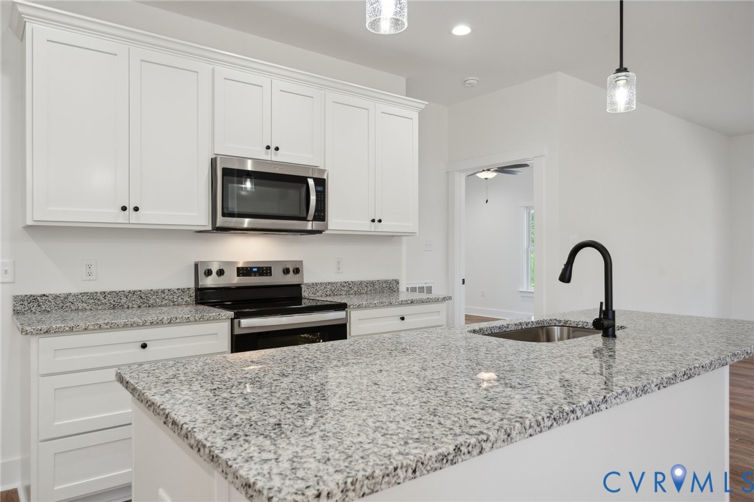 75 Oak Hill Road Cumberland, VA 23040 - Photo 17 of 34 a kitchen with granite countertop a stove and a white cabinets