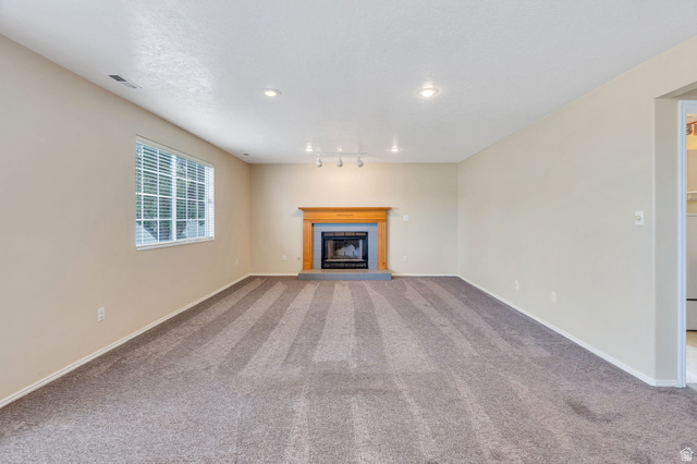 886 West 1700th Street North Mapleton, UT 84664 - Photo 6 of 21 Recessed lighting, window with blinds, carpeted flooring, fireplace with wood mantel, track lighting