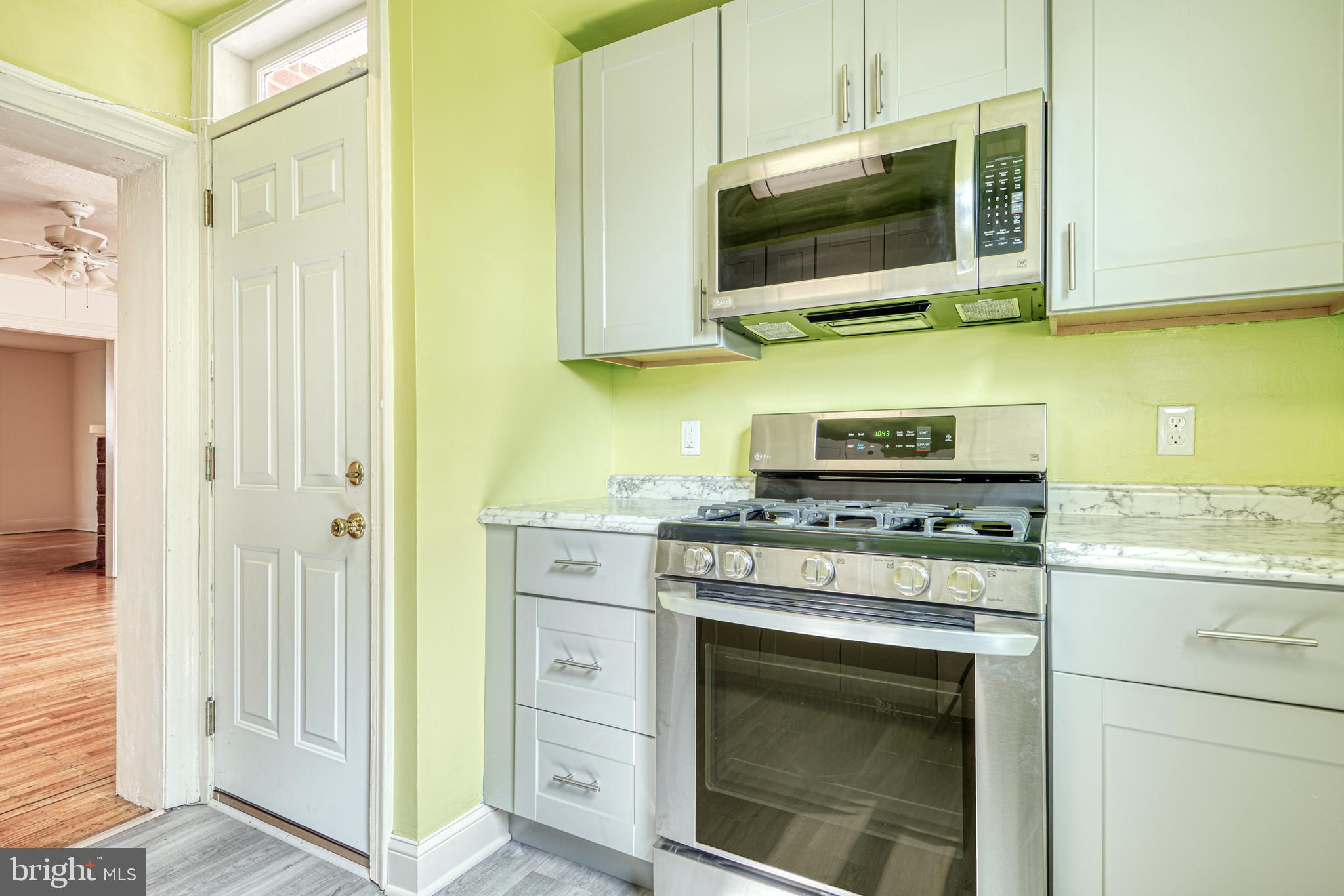 3621 Elkader Road Baltimore, MD 21218 - Photo 13 of 32 a kitchen with stainless steel appliances granite countertop a stove and a microwave