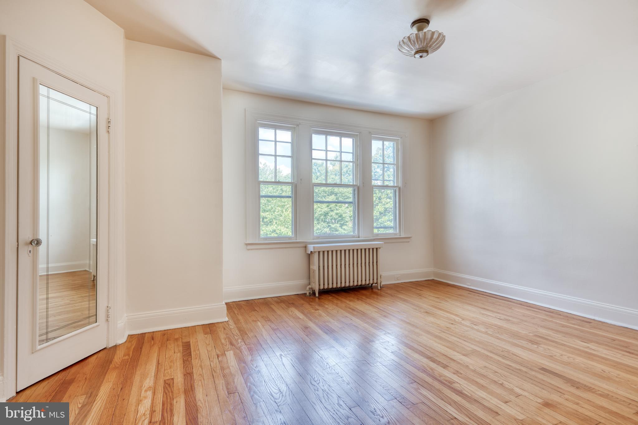 3621 Elkader Road Baltimore, MD 21218 - Photo 18 of 32 an empty room with wooden floor and windows