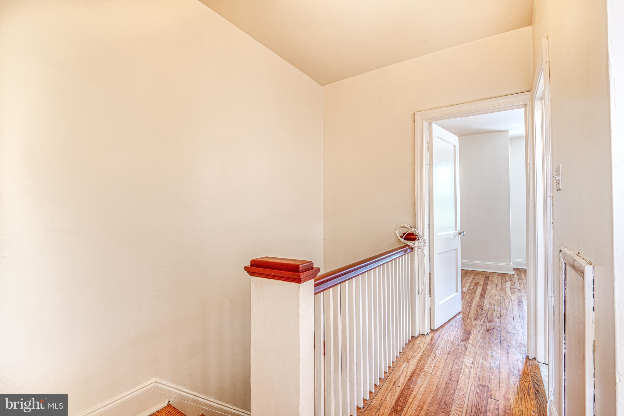 3621 Elkader Road Baltimore, MD 21218 - Photo 22 of 32 a view of a hallway with wooden floor and stairs