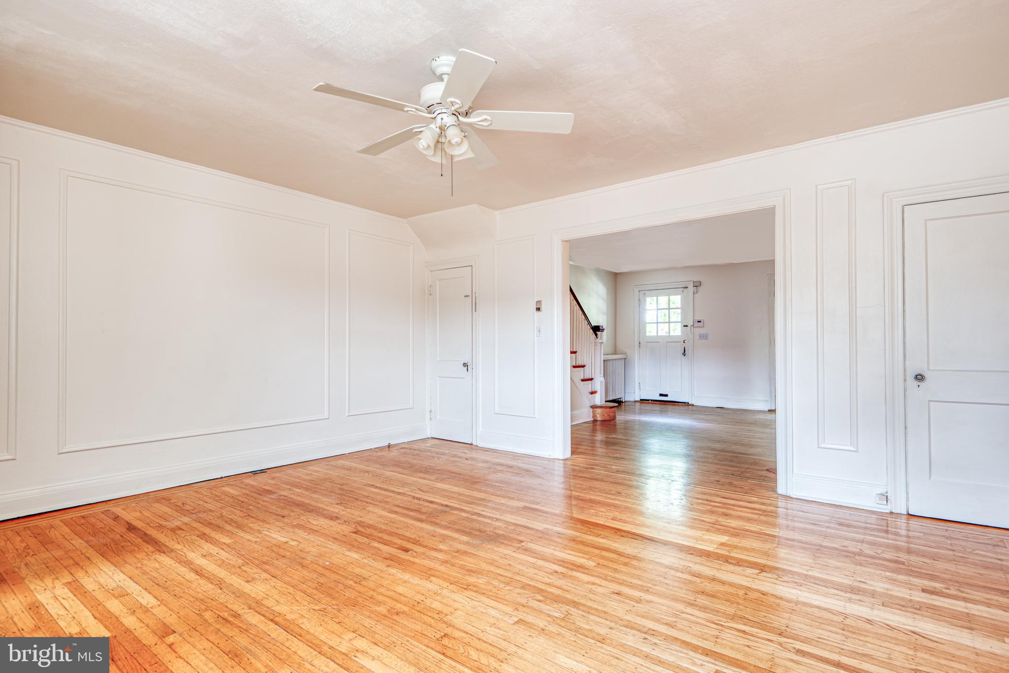3621 Elkader Road Baltimore, MD 21218 - Photo 6 of 32 an empty room with wooden floor and chandelier fan