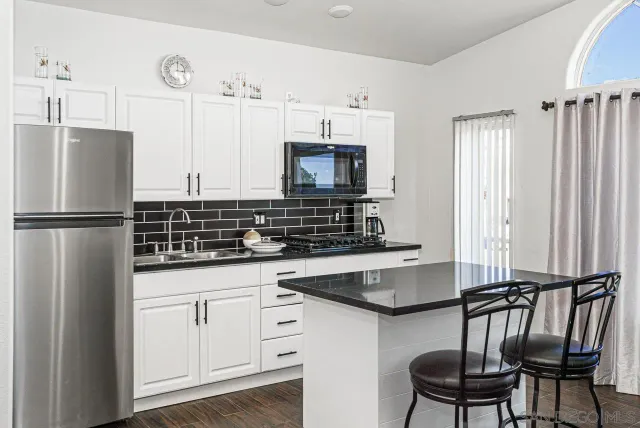 a kitchen with stainless steel appliances a sink cabinets and a refrigerator