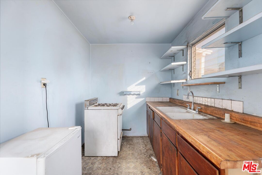 1650 South Rimpau Boulevard Los Angeles, CA 90019 - Photo 31 of 52 a kitchen with a sink stove and refrigerator