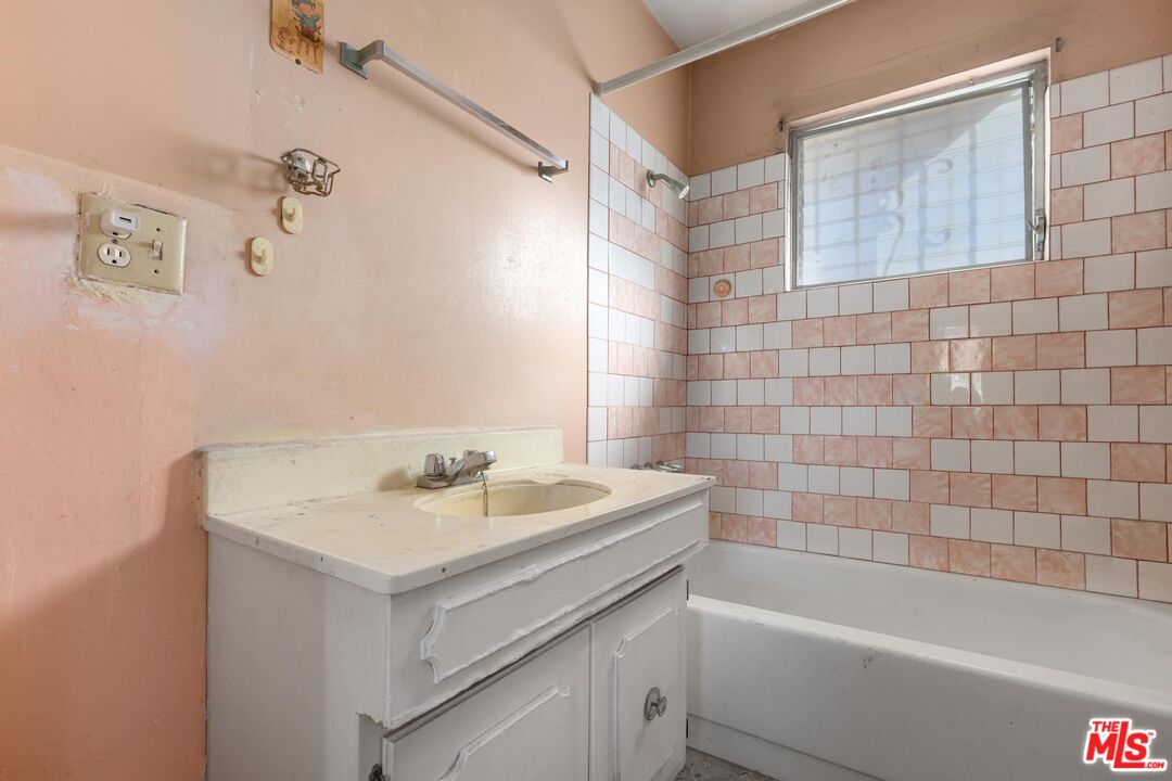 1650 South Rimpau Boulevard Los Angeles, CA 90019 - Photo 37 of 52 a bathroom with a sink a mirror and a bathtub