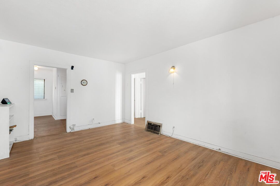 1650 South Rimpau Boulevard Los Angeles, CA 90019 - Photo 6 of 52 a view of an empty room with wooden floor and a bathroom
