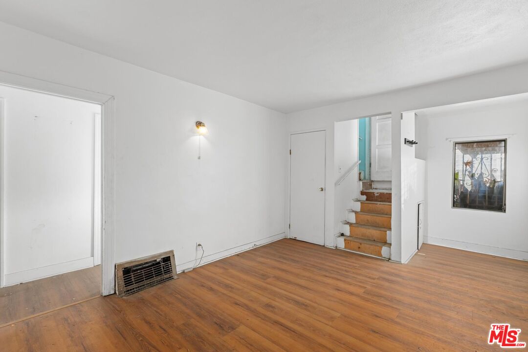 1650 South Rimpau Boulevard Los Angeles, CA 90019 - Photo 9 of 52 an empty room with wooden floor and windows