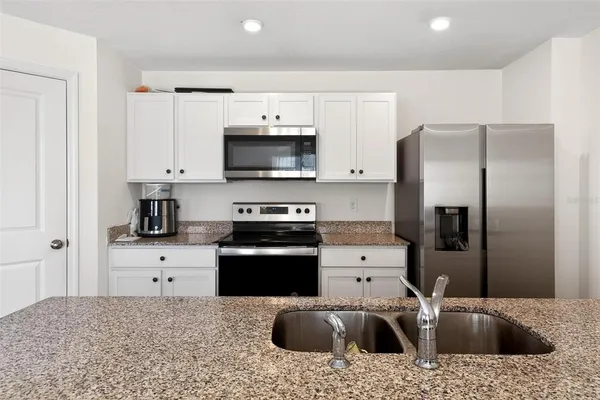 a kitchen with a refrigerator sink and stove