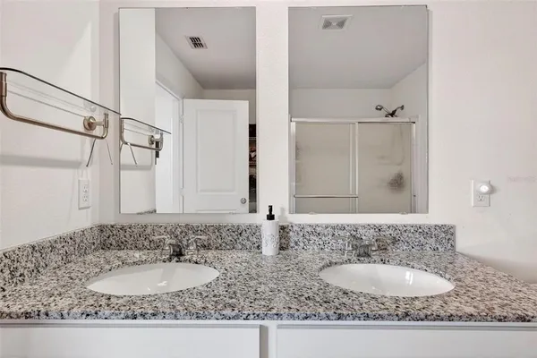 a bathroom with a granite countertop sink and a mirror