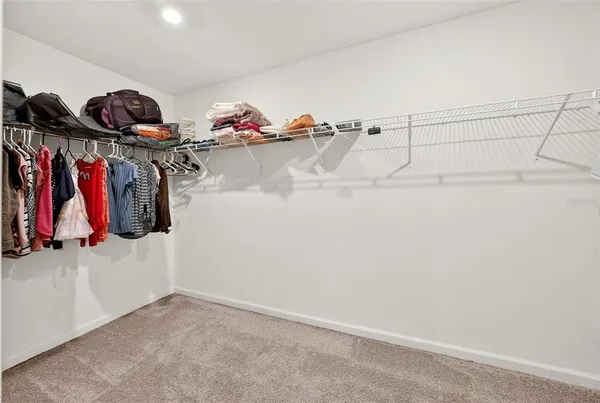 a view of walk in closet with clothes