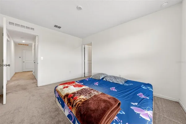 a bedroom with a bed and a painting on the wall