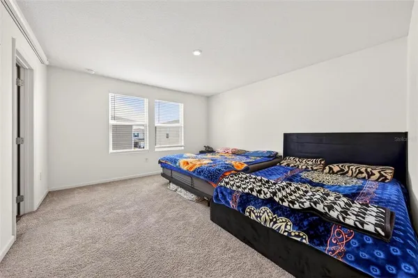 a bed sitting in a bedroom next to a window with lamp