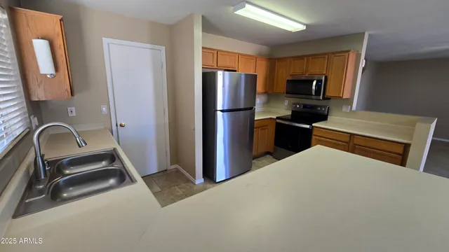 a kitchen with stainless steel appliances a refrigerator microwave and sink