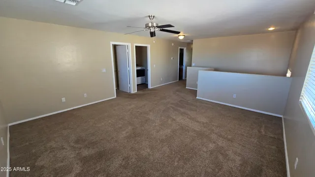 en empty room with windows and ceiling fan