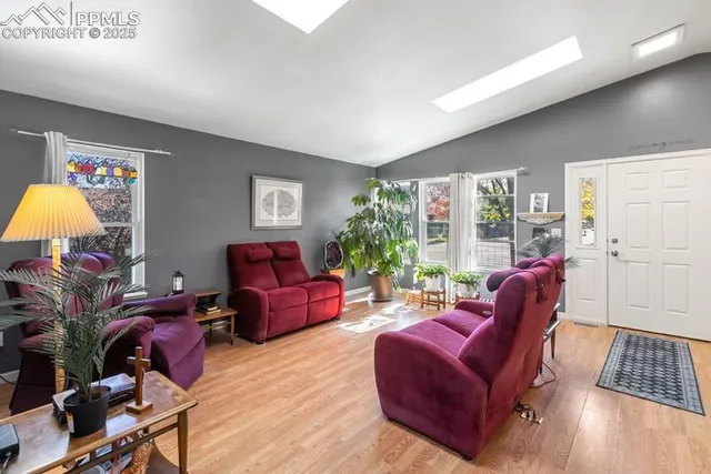 a living room with furniture fireplace and a large window