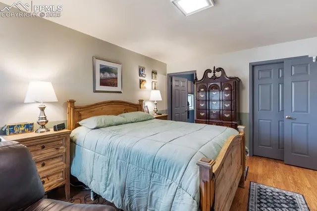 a bedroom with a bed and a lamp on dresser