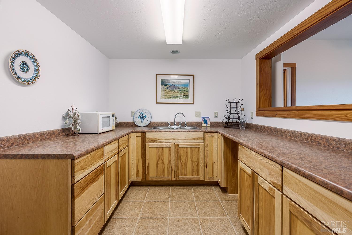 2151 Guntly Road Philo, CA 95466 - Photo 34 of 43 a spacious bathroom with a granite countertop sink a mirror and a bathtub