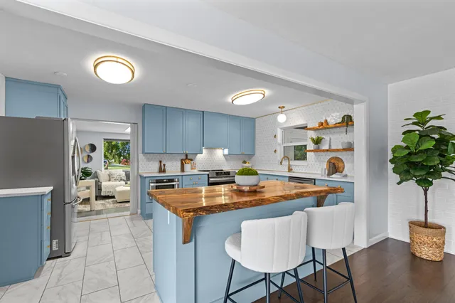 a kitchen with stainless steel appliances granite countertop a refrigerator and a stove top oven