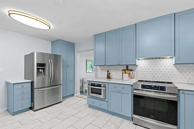 a kitchen with cabinets stainless steel appliances and a counter space