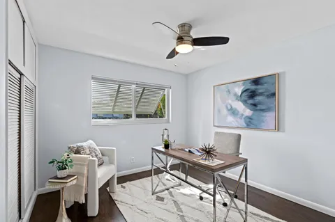 a view of a workspace with furniture and a window