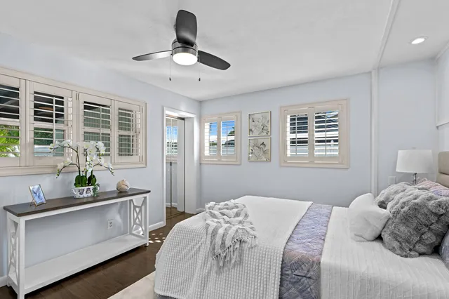 a bedroom with a bed a dresser next to a window