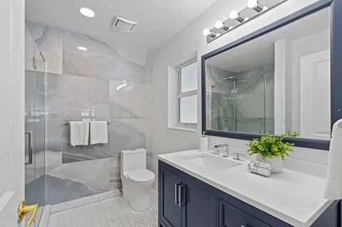 a bathroom with a sink a toilet and mirror