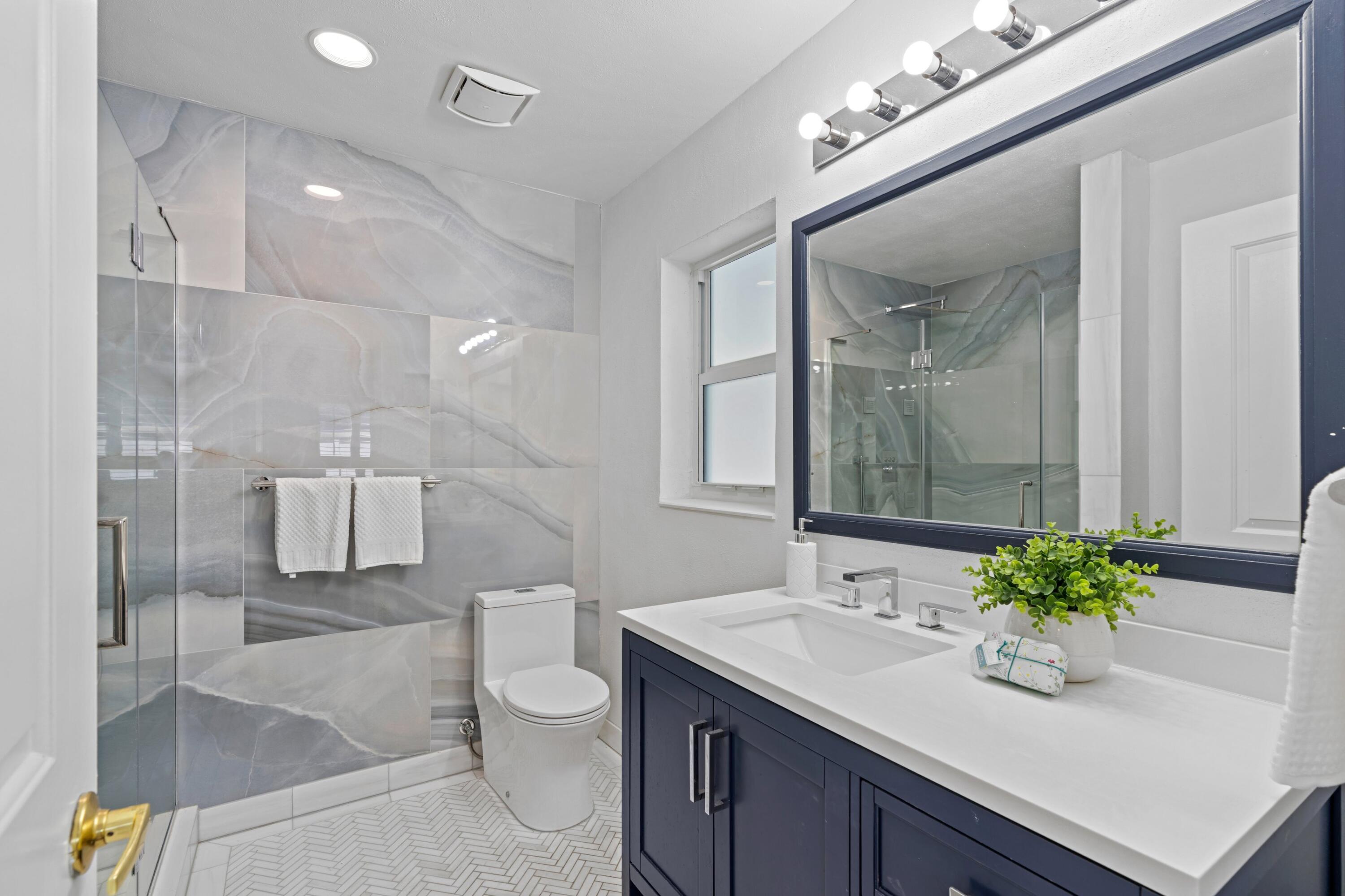 541 Kingfish Road North Palm Beach, FL 33408 - Photo 28 of 43 a bathroom with a sink a toilet and mirror