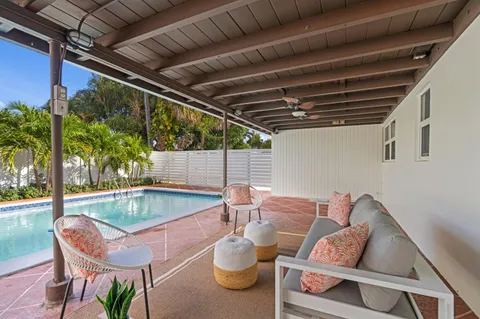 a patio with a table and chairs and potted plants