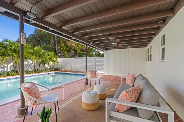 a patio with a table and chairs and potted plants