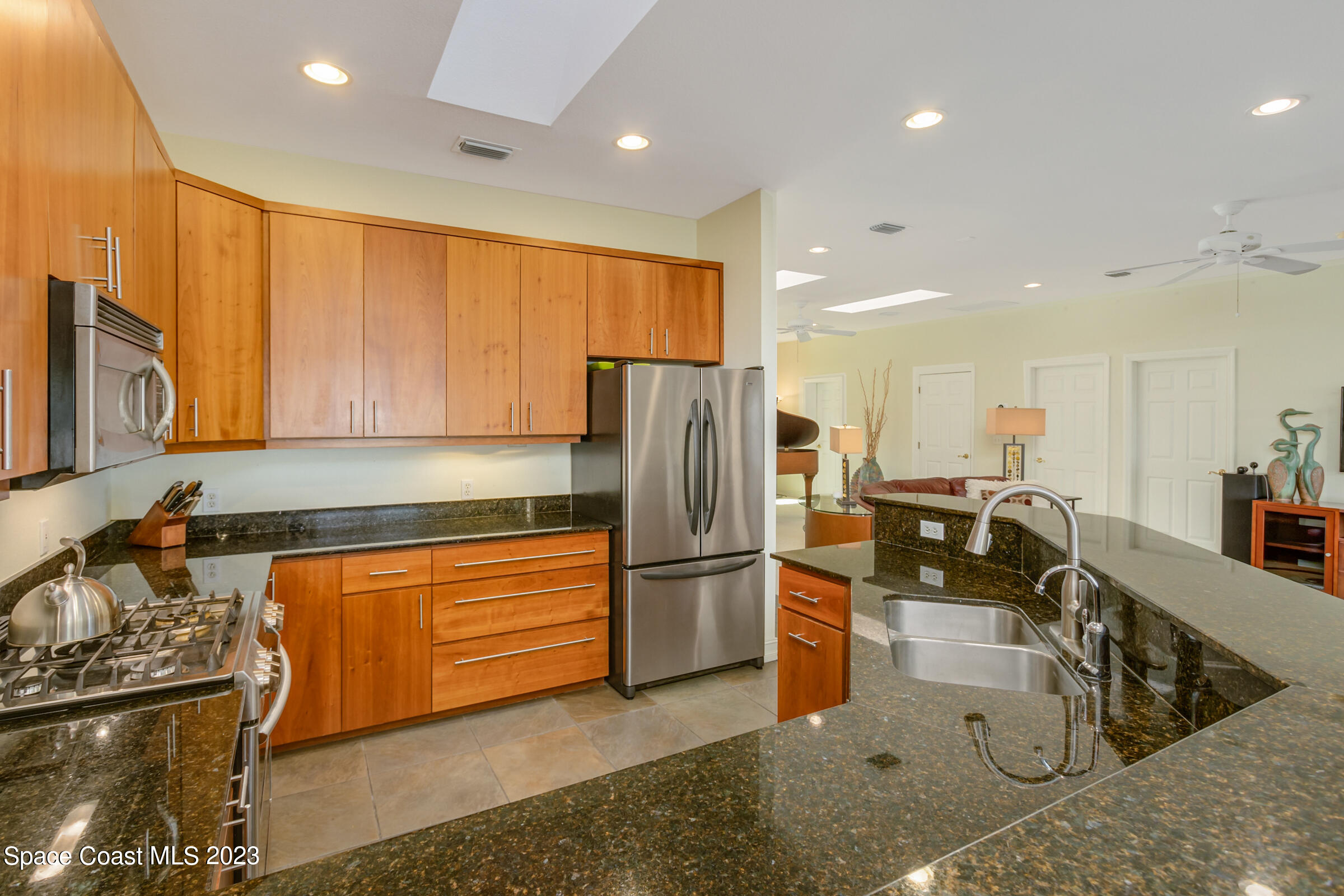 4553 Coquina Ridge Drive Melbourne, FL 32935 - Photo 17 of 51 a kitchen with stainless steel appliances granite countertop a refrigerator a stove and a sink with wooden floor