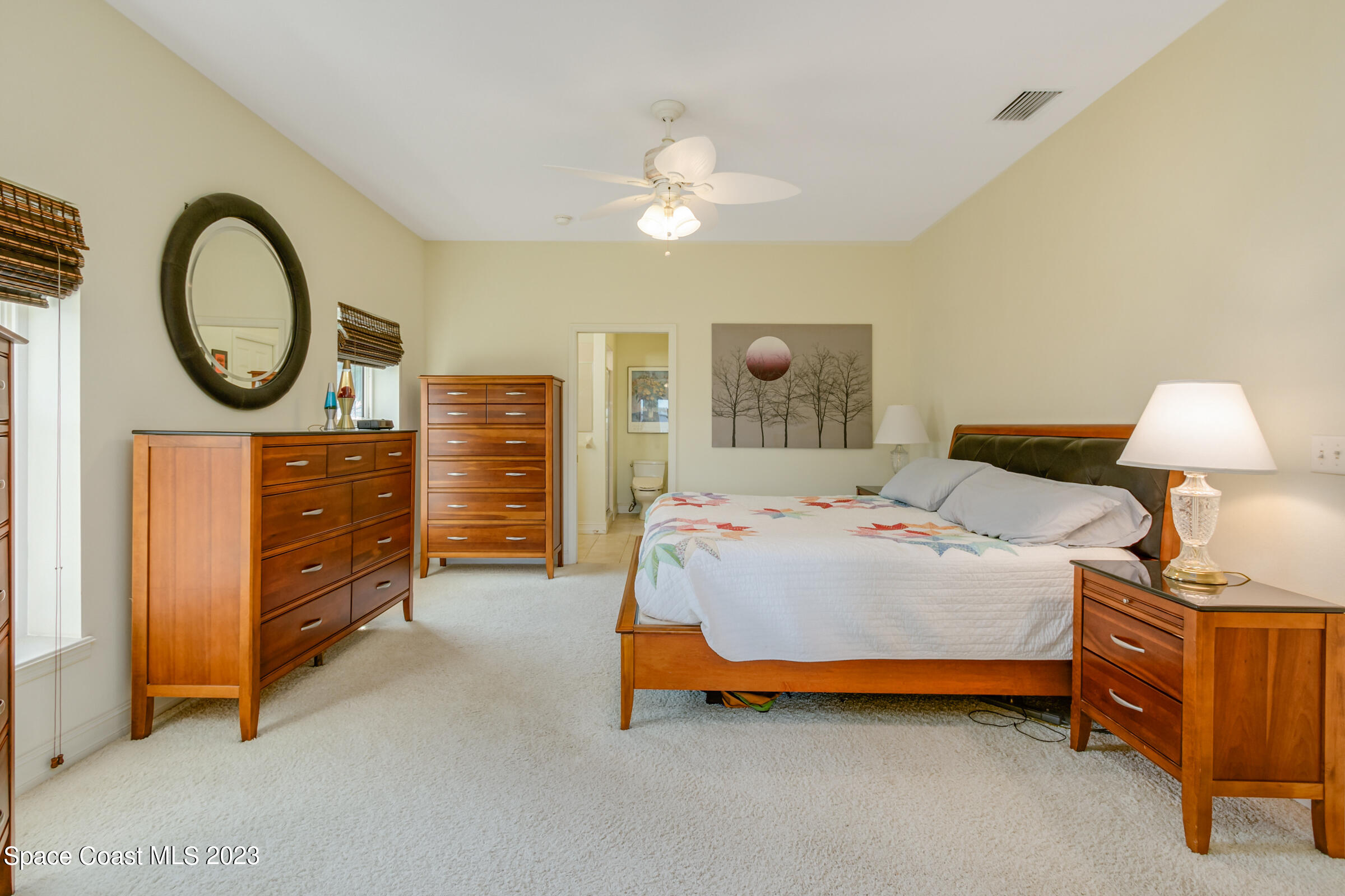 4553 Coquina Ridge Drive Melbourne, FL 32935 - Photo 22 of 51 a bedroom with a bed and a chandelier