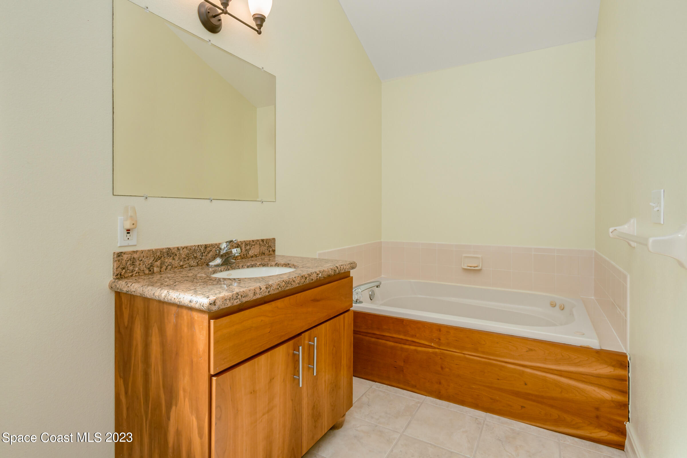 4553 Coquina Ridge Drive Melbourne, FL 32935 - Photo 24 of 51 a bathroom with a granite countertop sink and a bathtub