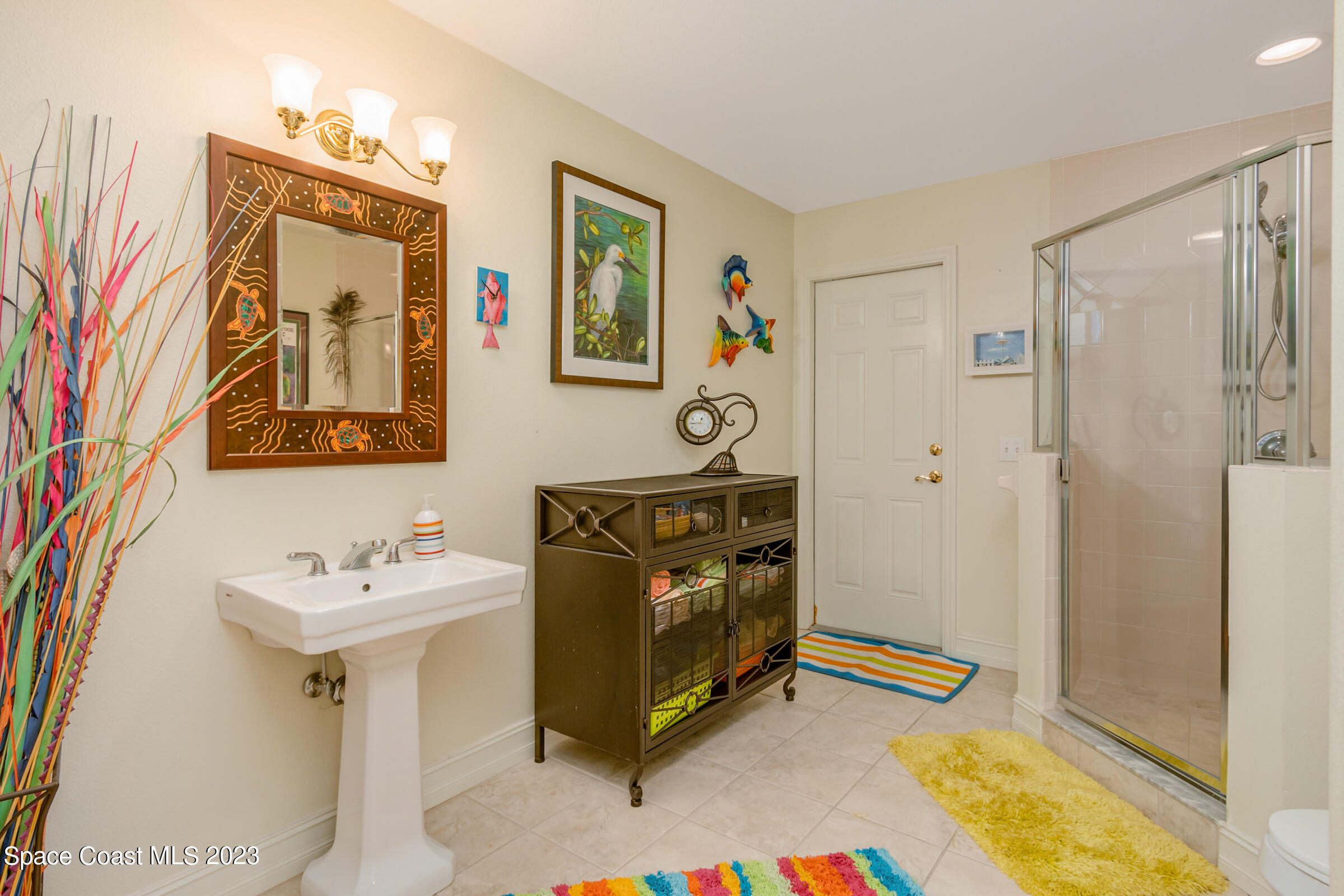 4553 Coquina Ridge Drive Melbourne, FL 32935 - Photo 27 of 51 a bathroom with a sink a mirror and a shower