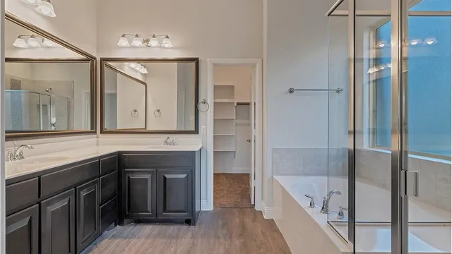 a bathroom with a tub a sink and mirrors